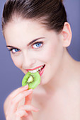 Woman eating kiwi fruit
