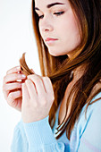 Woman inspecting her hair