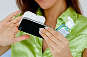 Woman cleaning her cell phone