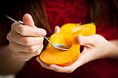 Woman eating persimmon