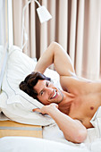 Man waking up and stretching in bed