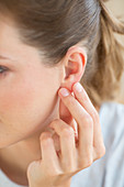 Woman massaging the ear lobe