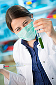 Girl wearing mask holding test tube