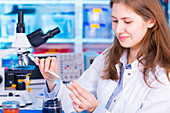 Woman placing sample on to microscope slide