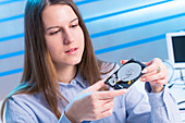 Young woman examining computer hard drive