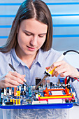 Young woman working on circuit board