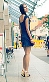 Young woman in short blue dress on pavement