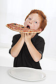 Boy eating large pizza