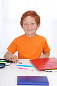 Boy doing homework, smiling