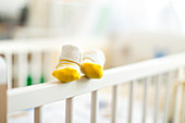 Baby booties on the edge of a cot
