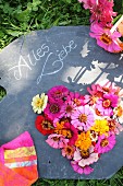 Herzförmiges Blumengesteck auf Schiefertafel mit Botschaft