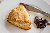 Buttermilk scone with black cherry confiture on a white plate
