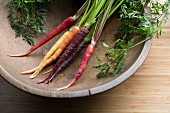 Rainbow carrots in an old wooden bowl