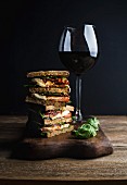 Panini with whole grain bread, mozzarella, cherry and dried tomatoes, basil served with glass of red wine