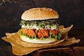 Carrot burger with clover sprouts on dark background