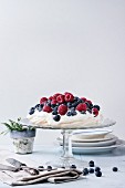 Vintage cake stand with Meringue dessert Pavlova with fresh blackberries and raspberrie
