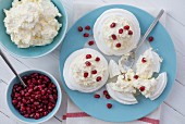 Meringue nests with fresh whipped cream and pomegranate seeds
