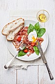 Schinkensalat mit pochiertem Ei, Tomaten, Basilikum und Brot