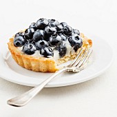 Blaubeer-Tartelett auf weißem Teller