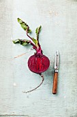 Ripe beetroot with leaves on textured background