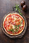 Pizza with ham, tomatoes and rucola