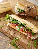 Rustic baguette with serrano ham, salami, rocket and tomato