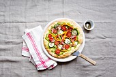 Pizza with avocado, zucchini, tomatoes, peppers and ham