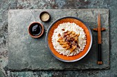 Eel on Rice with sauce and sesame on stone slate background