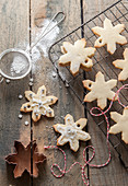 Homemade snowflake shaped Christmas biscuits cooling on a wiring rack