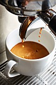 Kaffee fliesst aus Kaffeemaschine