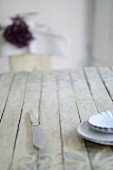 Holztisch mit Tellerstapel und Messer