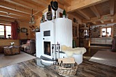 Masonry wood-burning stove in open-plan interior of wooden cabin