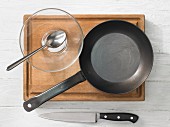 Kitchen utensils: pan, knife, spoon, glass bowl