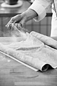 A baker dusting flour