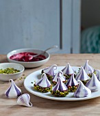Mini pavlovas with cherry sauce and pistachios