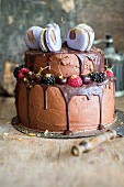 A chocolate cake decorated with macarons and berries