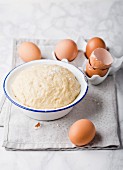 Dough in an enamel bowl and eggs