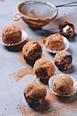 Homemade chocolate truffles with marzipan and cocoa powder over gray matal surface