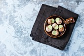 Uncooked Escargots de Bourgogne - Snails with herbs butter, gourmet dish, in traditional ceramic pan