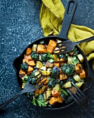Fried sweet potato, potato and brussels sprouts with leaf parsley
