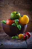 Heritage tomatoes with Basil in a Wooden Bowl