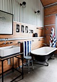 Vintage Badewanne und Waschtisch mit Aufsatzbecken im Bad mit Trapezblech-Verkleidung und mit Holzverkleidung