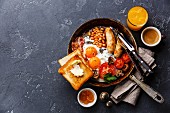 Englisch Frühstück mit Spiegelei, Würstchen, Speck, Bohnen, Toast und Kaffee