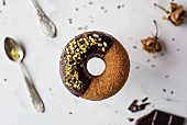 Donut with chocolate and pistachios on marble table