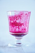An empty glass with remnants of beetroot juice