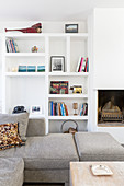 View across sofa to fitted shelving next to fireplace