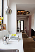 View from open-plan kitchen into foyer with stained-glass ceiling light