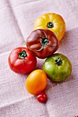Various coloured tomatoes on a linen cloth