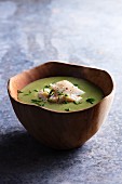 Pea soup with cod in a wooden bowl