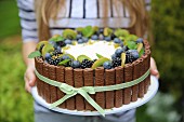 Birthday cake with whipped cream and fruits-blueberries, blackberries and kiwi